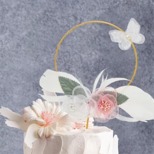 Este topo de bolo apresenta um belo design de flores de metal e penas de ouro